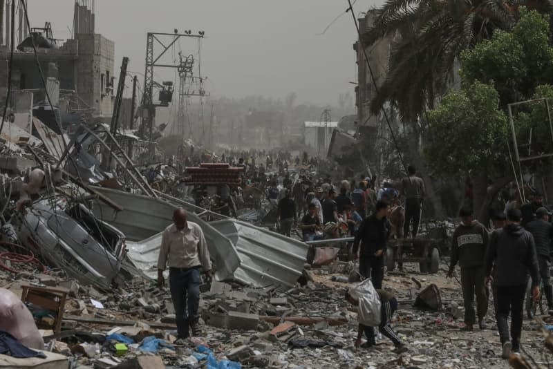 Palestinians inspect the damage to a building in the Nuseirat refugee Camp after withdrawal of Israel Defence Forces (IDF). Omar Naaman/dpa