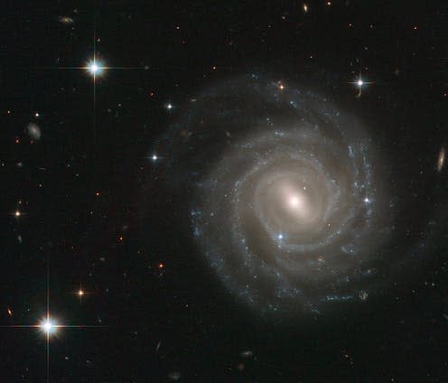<span class="caption">The barred spiral galaxy UGC 12158.</span> <span class="attribution"><a class="link " href="https://en.wikipedia.org/wiki/Barred_spiral_galaxy#/media/File:UGC_12158.jpg" rel="nofollow noopener" target="_blank" data-ylk="slk:Wikimedia">Wikimedia </a>, <a class="link " href="http://creativecommons.org/licenses/by-sa/4.0/" rel="nofollow noopener" target="_blank" data-ylk="slk:CC BY-SA">CC BY-SA</a></span>