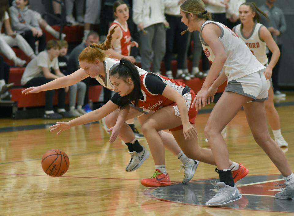 Bedford's Aubrey Hensey and Sophia Bussell of Monroe battle for a loose ball as Victoria Gray of Bedford looks on. Bedford won 55-33 in the semifinals of the Division 1 District at Bedford on Wednesday, March 6, 2024.
