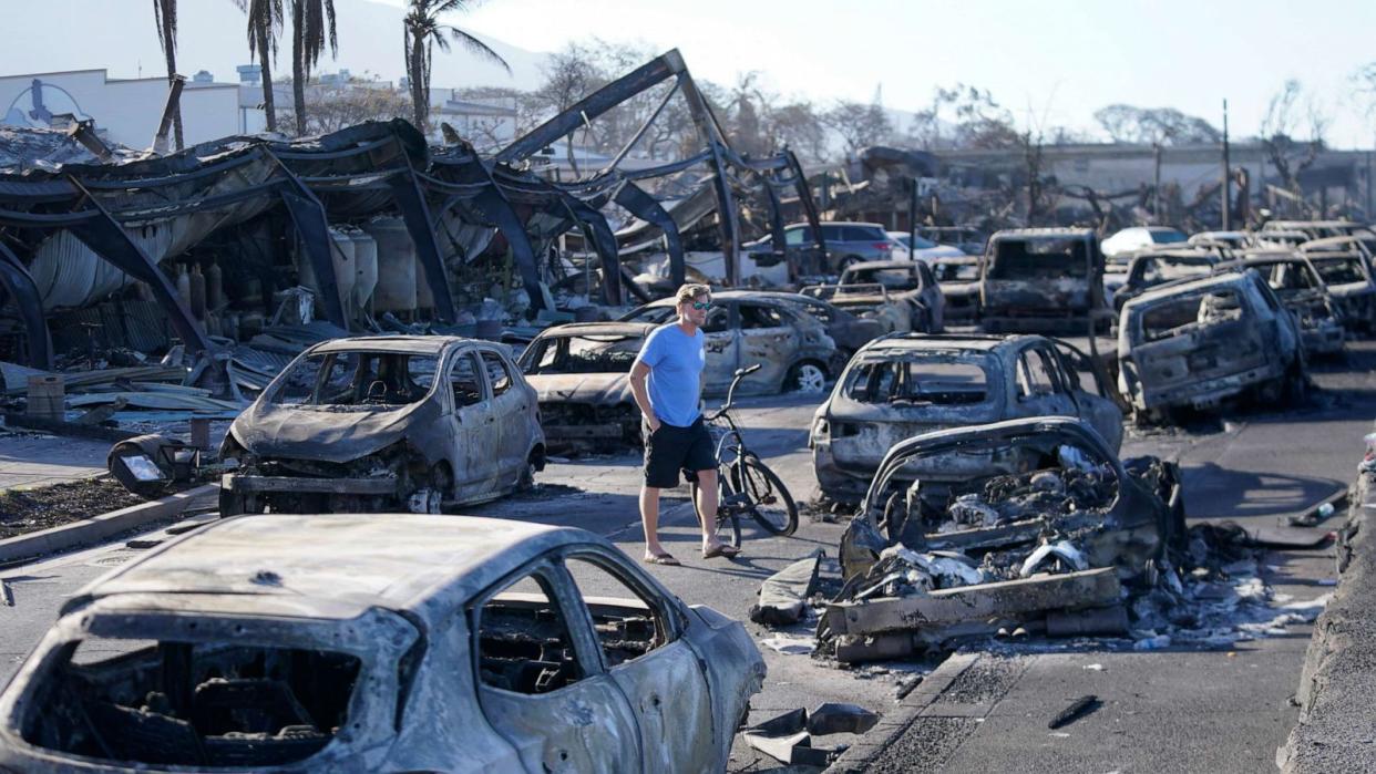 PHOTO: A man walks through wildfire destruction, Aug. 11, 2023, in Lahaina, Hawaii. (Rick Bowmer/AP)