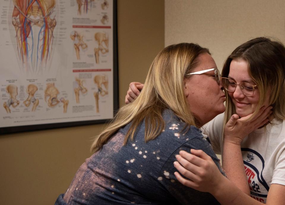 Melissa Heichelbech plants a kiss on her senior softball star, Kinsly, after hearing good news on her daughter's recovery at Orthopedic Associates in Newburgh, Ind.,  Friday morning, April 15, 2022. Her doctor had given her the OK to resume light exercise with a chance of rejoining her team in the post season.