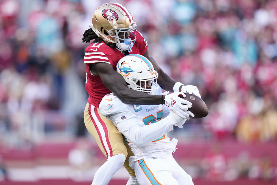 Miami Dolphins cornerback Xavien Howard, bottom, intercepts a pass in front of San Francisco 49ers wide receiver Brandon Aiyuk during the first half of an NFL football game in Santa Clara, Calif., Sunday, Dec. 4, 2022. (AP Photo/Godofredo A. Vásquez)
