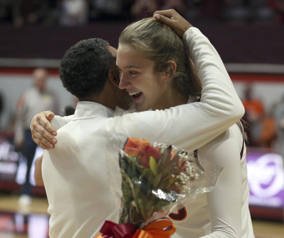 Virginia Tech coach Kenny Brooks, left, and Elizabeth Kitley (33) embrace during a senior ceremony before the team's NCAA college basketball game against North Carolina State on Sunday, Feb. 19, 2023, in Blacksburg, Va. (Matt Gentry/The Roanoke Times via AP)