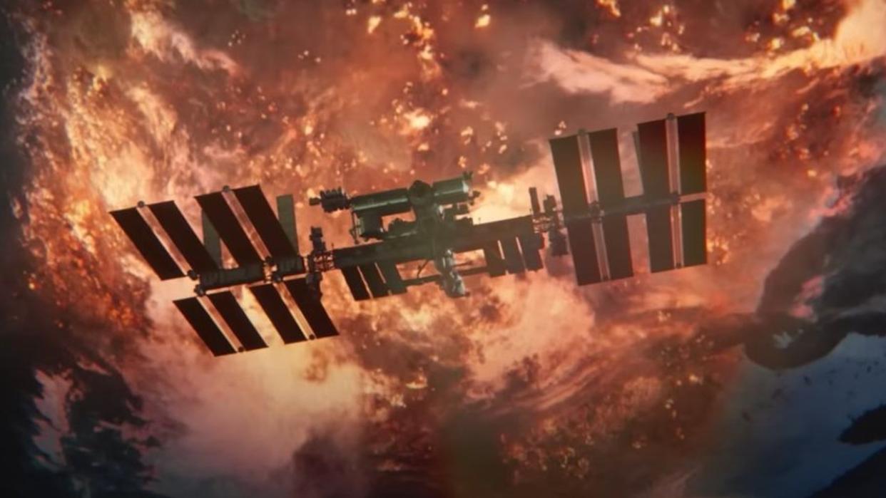  A large cross-shaped space station floats above an Earth covered in flames. 