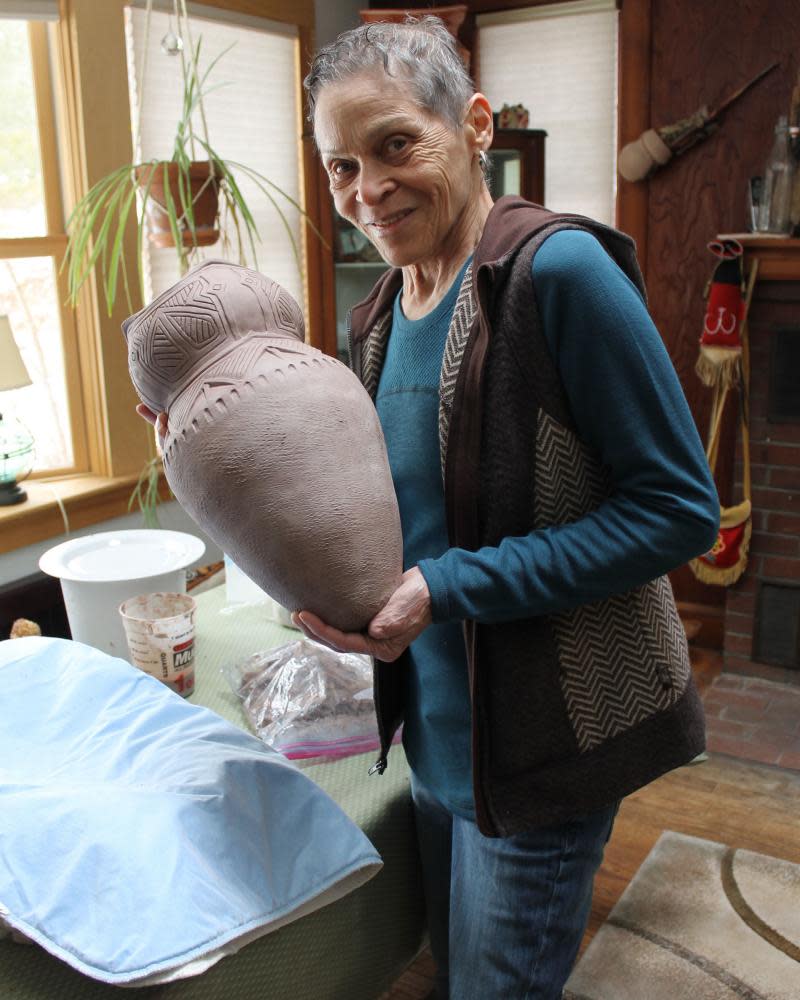 Wampanoag artist Ramona Peters with her ceramic cooking pot, on display at Mayflower 400: Legend & Legacy exhibition.