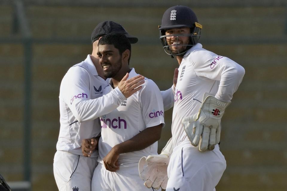 England's Rehan Ahmed, center, celebrates with teammates after taking the wicket of Pakistan's Faheem Ashraf during the first day of third test cricket match between England and Pakistan, in Karachi, Pakistan, Saturday, Dec. 17, 2022. (AP Photo/Fareed Khan)