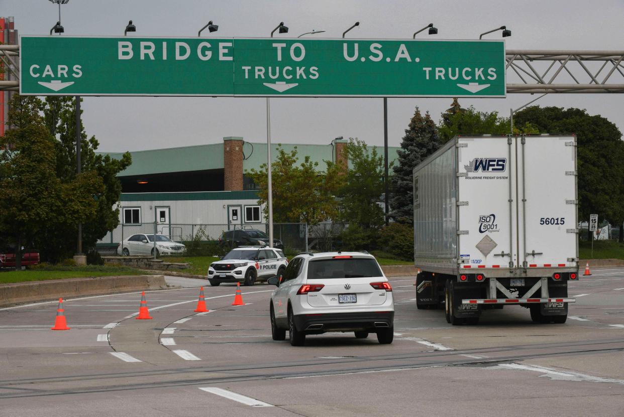 Traffic moves towards a police car by the Ambassador Bridge border crossing in Windsor, Ontario, Canada.