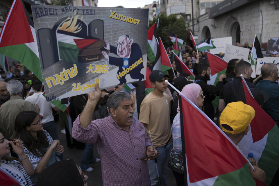 Palestinian protesters hold posters and chant anti Israel slogans during a demonstration in solidarity with the Gaza Strip, in the West Bank city of Ramallah, Friday, Oct. 20, 2023. (AP Photo/Nasser Nasser)