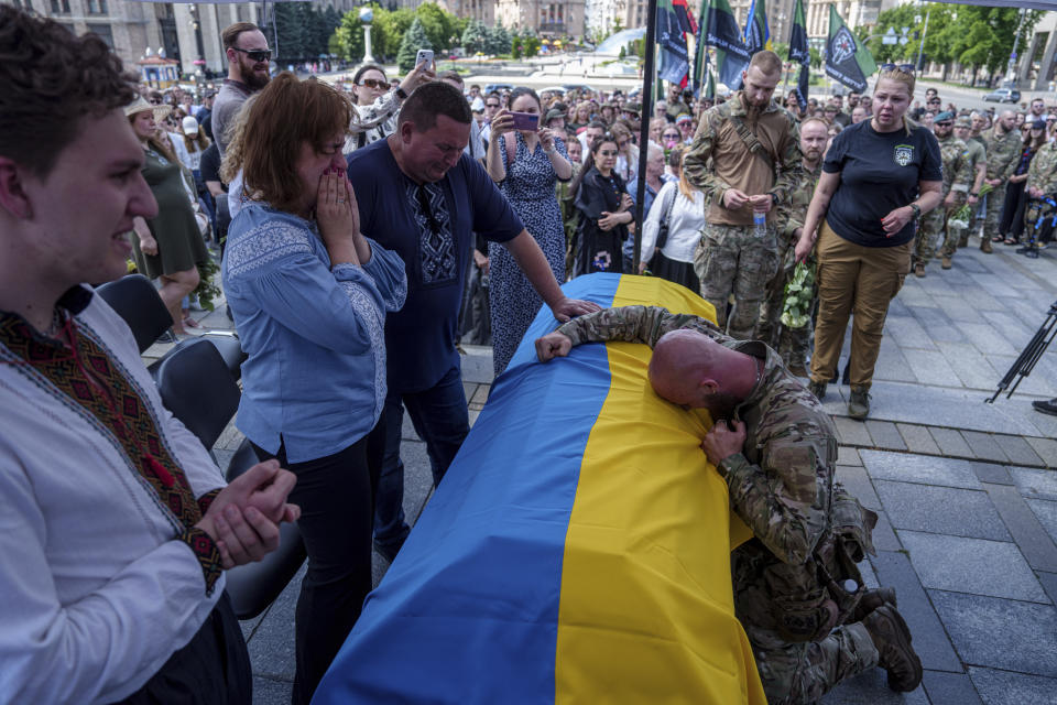 A Ukrainian serviceman cries over the coffin of Ukrainian journalist and volunteer combat medic Iryna Tsybukh during a memorial service on Independence square in Kyiv, Ukraine, Sunday, June 2, 2024. Nearly 1,000 people attended a ceremony Sunday honoring the memory of Ukrainian journalist Iryna Tsybukh, who was killed in action while serving as a combat medic a few days before her 26th birthday. Tsybukh was killed while on rotation in Kharkiv area, where Russia started its offensive nearly a month ago. (AP Photo/Evgeniy Maloletka)