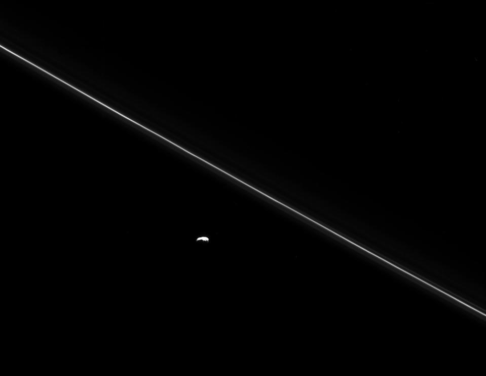 <p>As Cassini hurtled toward its fatal encounter with Saturn, the spacecraft turned to catch this final look at Saturn’s moon Pandora next to the thin line of the F ring. Over the course of its mission, Cassini helped scientists understand that Pandora plays a smaller role than they originally thought in shaping the narrow ring. (Photo: NASA/JPL-Caltech/Space Science Institute) </p>