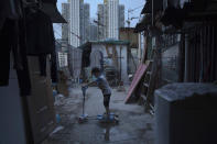 <p>A five-year-old boy plays outside his tiny home, which is made of concrete and corrugated metal, on the terrace of an apartment block in Hong Kong, April 20, 2017. He lives with his parents in an illegal rooftop hut located next to a public housing estate. (Photo: Kin Cheung/AP) </p>