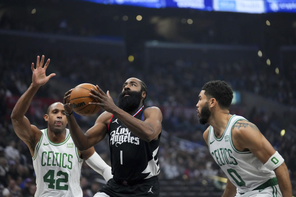 Los Angeles Clippers guard James Harden (1) drives to the basket against Boston Celtics center Al Horford (42) and forward Jayson Tatum (0) during the first half of an NBA basketball game in Los Angeles, Saturday, Dec. 23, 2023. (AP Photo/Eric Thayer)