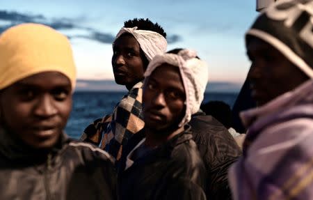 Migrants are seen as they stand on the deck of MV Aquarius, a search and rescue ship run in partnership between SOS Mediterranee and Medecins Sans Frontieres on their way to Spain June 14, 2018. Picture taken June 14, 2018. Karpov / SOS Mediterranee/handout via REUTERS