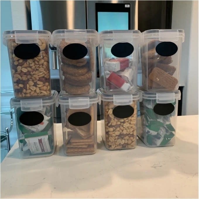airtight containers filled with different snacks and nuts on kitchen counter