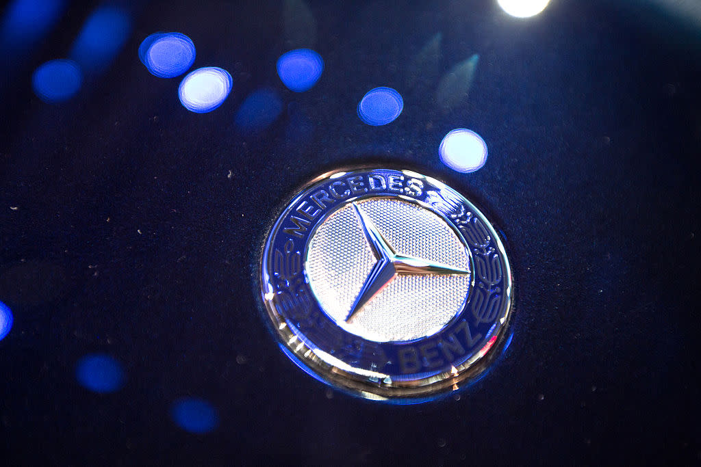 The logo of Mercedes-Benz, seen in blue light.