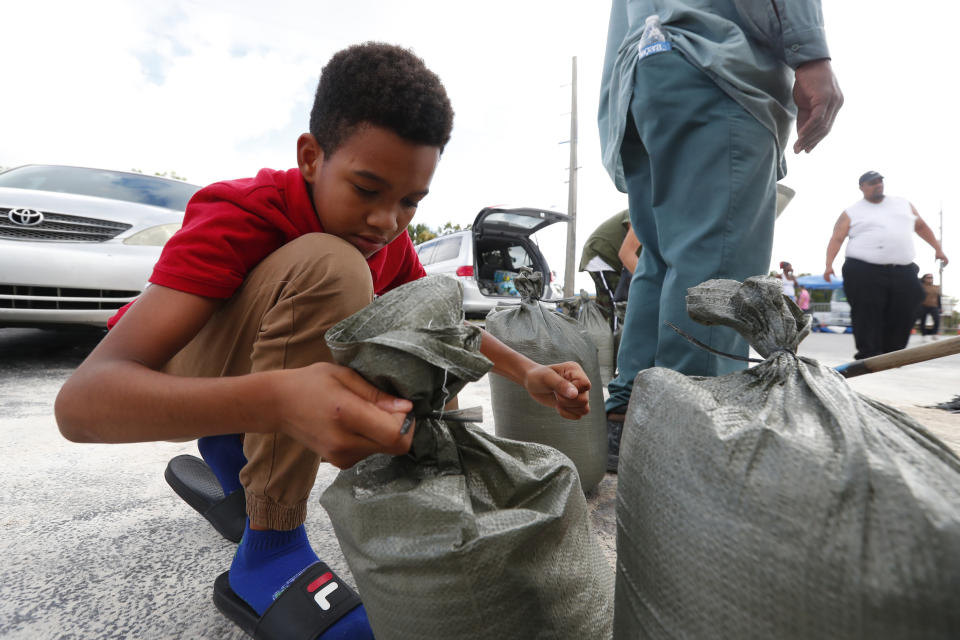 Isaiah Elie, 11, helps tie sandbags as his family fills them in preparation for Hurricane Dorian, Friday, Aug. 30, 2019, in Hallandale Beach, Fla., as the town allowed residents to fill up sandbags until they ran out. All of Florida is under a state of emergency and authorities are urging residents to stockpile a week&#39;s worth of food and supplies as Hurricane Dorian gathers strength and aims to slam the state as soon as Monday as a Category 4 storm. (AP Photo/Wilfredo Lee)