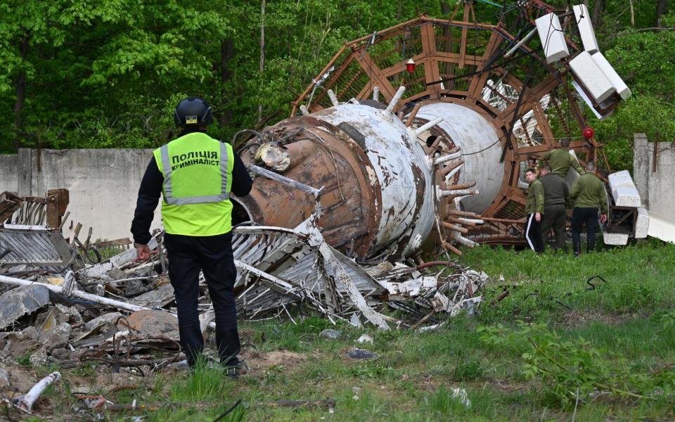 An emergency worker stands next to wreckage from the Kharkiv TV tower