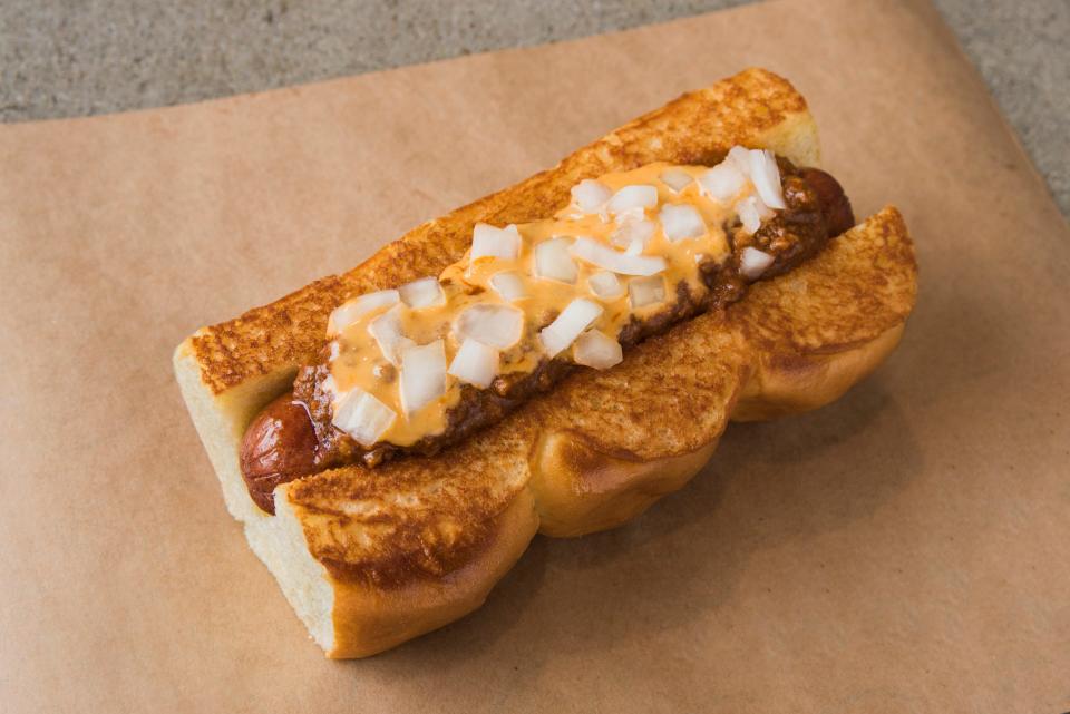 The Dog Haus Chili Idol hot do is topped with topped with signature chili, cheddar sauce and onions.