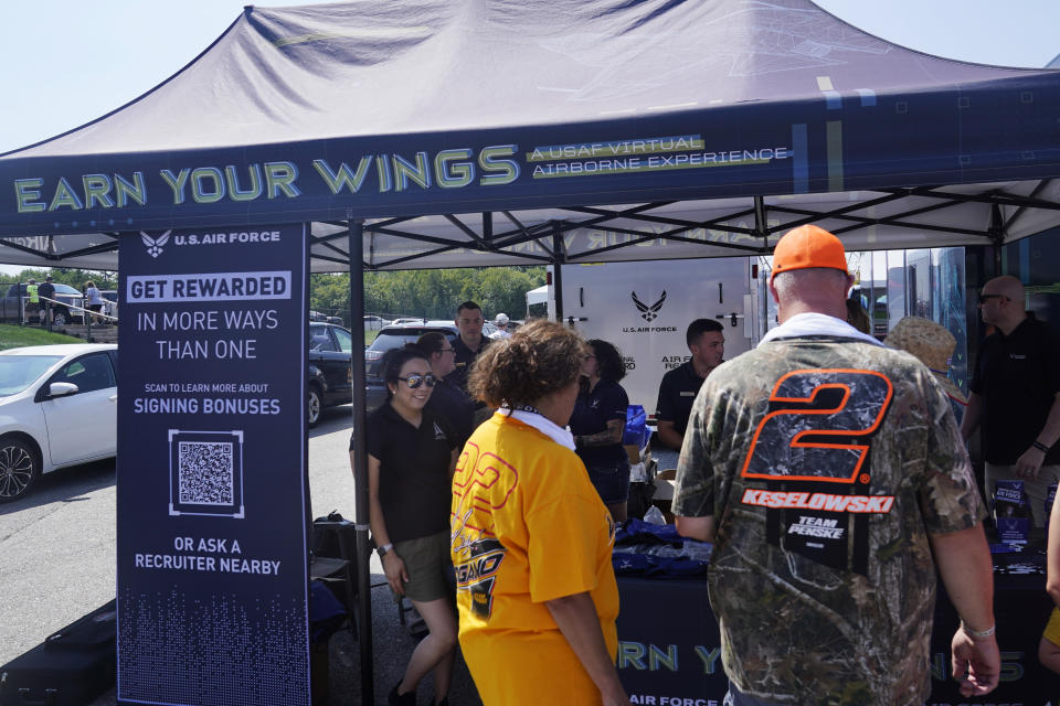 Racing fans stop at the U.S. Air Force recruiting tent prior to a NASCAR race at the New Hampshire Motor Speedway, Sunday, July 17, 2022, in Loudon, N.H. These are tough times for military recruiters. All services are having problems finding young people who want to join and can meet the physical, mental and moral requirements. Recruiters are offering bigger bonuses and other incentives to those who sign up. And they are seizing on the boost that Hollywood may offer – such as the buzz over Top Gun. (AP Photo/Charles Krupa)