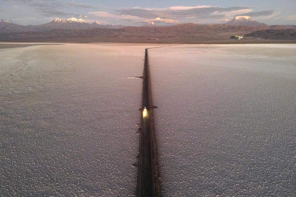A car drives down a road through the Salar de Atacama salt flat near the Albemarle lithium mine in Chile, Monday, April 17, 2023. (AP Photo/Rodrigo Abd)