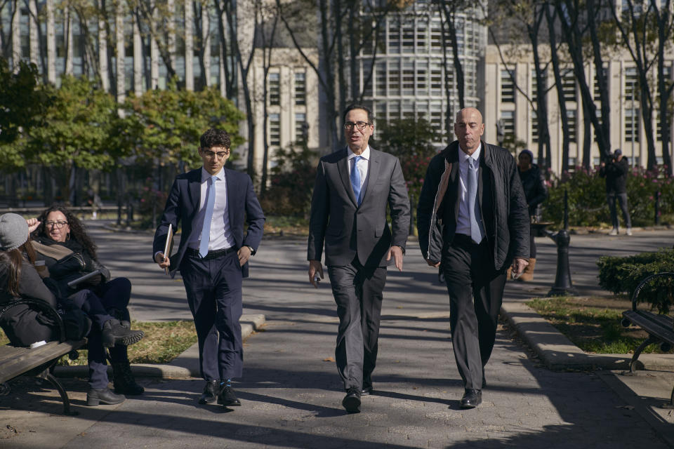 Former United States Secretary of the Treasury, Steven Mnuchin, center, leaves the Brooklyn Federal Court on Thursday, Oct. 20, 2022, in the Brooklyn borough of New York. (AP Photo/Andres Kudacki)