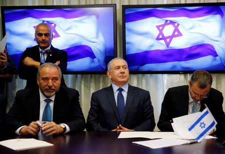 Avigdor Lieberman, head of far-right Yisrael Beitenu party, (L) sits next to Israeli Prime Minister Benjamin Netanyahu (C) as they sign a coalition deal to broaden the government's parliamentary majority, at the Knesset, the Israeli parliament in Jerusalem May 25, 2016. REUTERS/Ammar Awad