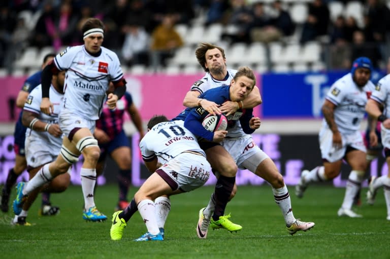 Stade Francais' fly half Jules Plisson (C) is tackled during the French Top 14 rugby union match between Stade Francais and Union Bordeux Begle, on March 5, 2017 at the Jean Bouin Stadium in Paris