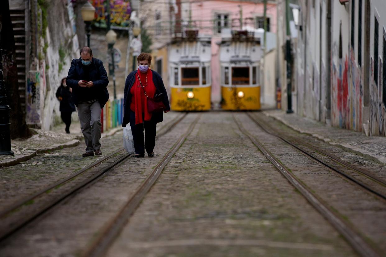 Personas con mascarilla caminan por Lisboa, que superó una situación crítica por el coronavirus