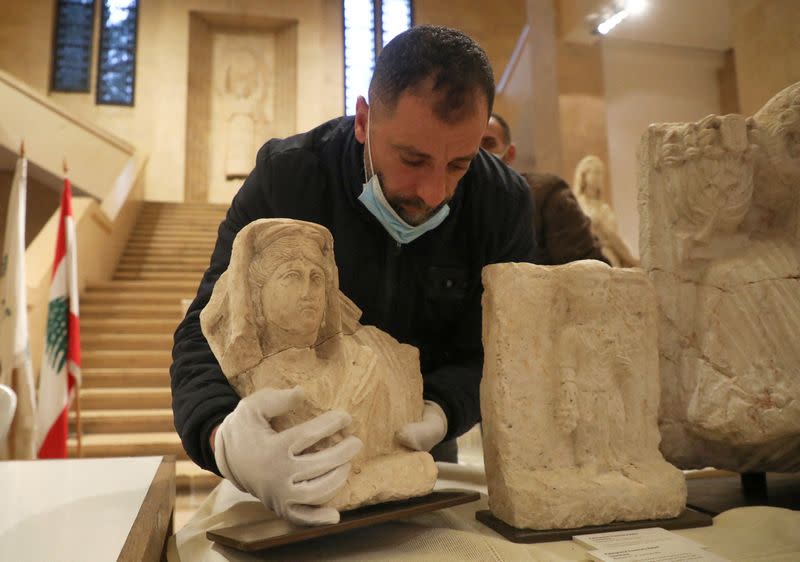 A man holds a Roman artifact from the ancient city of Palmyra during a handover ceremony hosted by Lebanon's National Museum in Beirut