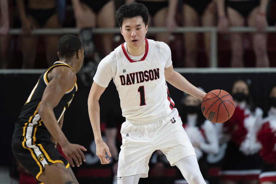 Davidson guard Hyunjung Lee (1) brings the ball up court while guarded by Virginia Commonwealth guard KeShawn Curry (11) during the second half of an NCAA college basketball game in Davidson, N.C., Wednesday, Jan. 26, 2022. (AP Photo/Jacob Kupferman)