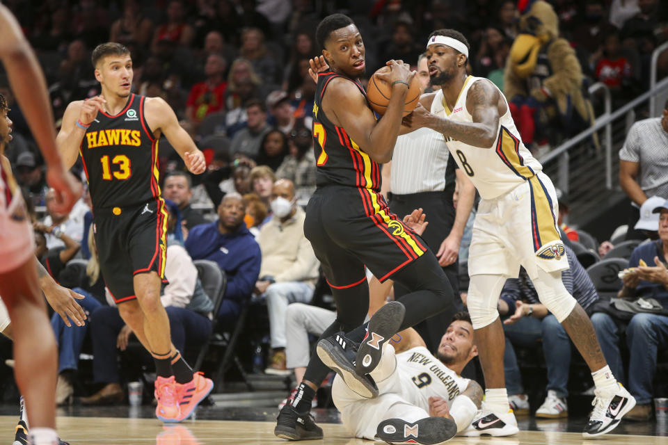 Atlanta Hawks forward Onyeka Okongwu (17) grabs a loose ball past New Orleans Pelicans center Willy Hernangomez (9) and forward Naji Marshall (8) in the second half of an NBA basketball game, Sunday, March 20, 2022, in Atlanta. (AP Photo/Brett Davis)