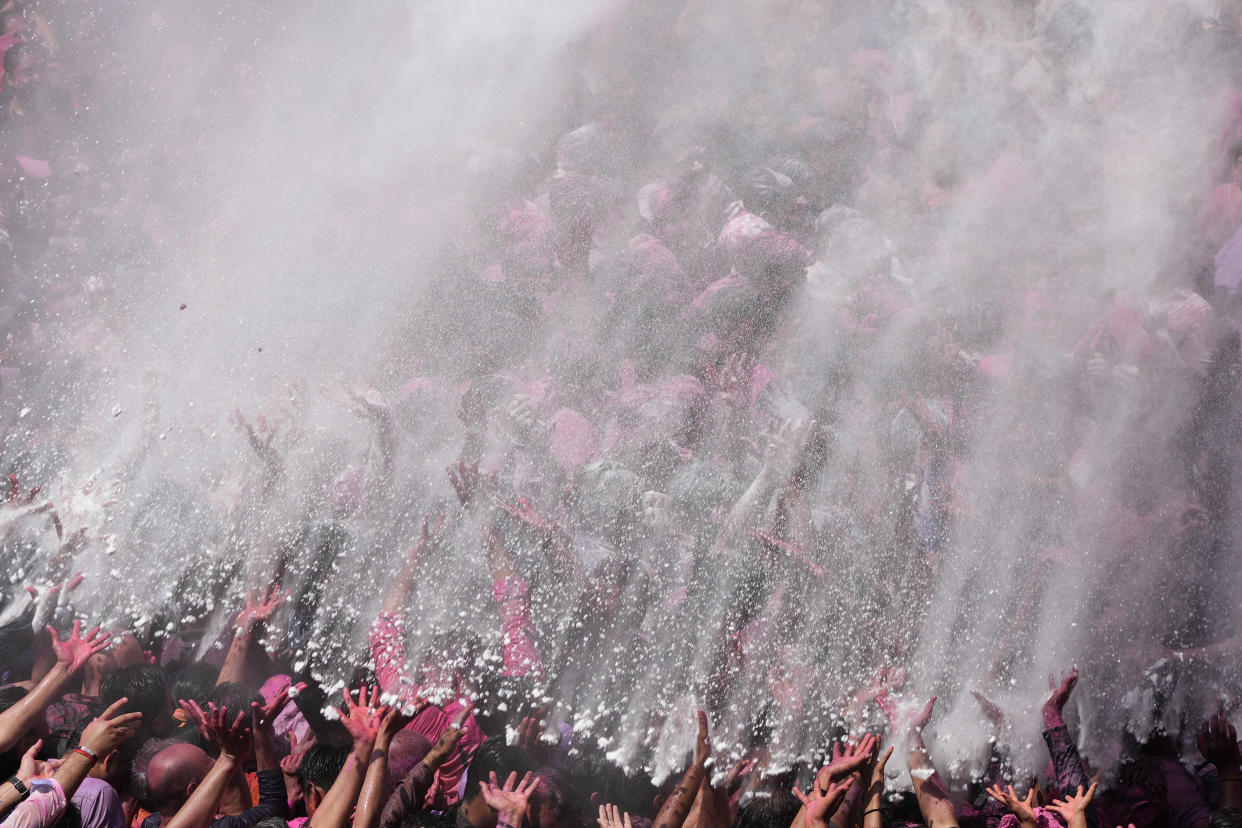 Devotees cheer as colored powder and water is sprayed on them during celebrations marking Holi at the Kalupur Swaminarayan temple in Ahmedabad, India, Wednesday, March 8, 2023. Millions of Indians on Wednesday celebrated the ''Holi" festival, dancing to the beat of drums and smearing each other with green, yellow and red colors and exchanging sweets in homes, parks and streets. Free from mask and other COVID-19 restrictions after two years, they also drenched each other with colored water. (AP Photo/Ajit Solanki)