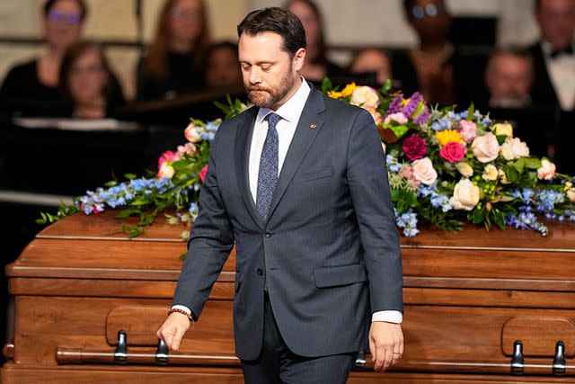 <p>Brynn Anderson/POOL/AFP/Getty</p> Jason Carter walks past the casket of his grandmother, Rosalynn Carter, at her tribute service on Nov. 28, 2023
