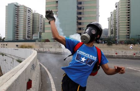 A demonstrator throws back a tear gas canister during a protest against Venezuelan President Nicolas Maduro's government in Caracas, Venezuela January 23, 2019. REUTERS/Manaure Quintero