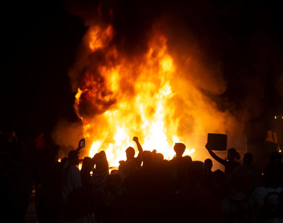 Protesters gather around a fire they set in the middle West 7th Ave. at Washington Street. in Eugene in protest over the killing of George Floyd in  Minneapolis, Minnesota on May 29, 2020.