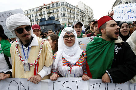 Students wearing traditional clothes hold banners and shout slogans during a protest calling on President Abdelaziz Bouteflika to quit, in Algiers, Algeria March 26, 2019. REUTERS/Ramzi Boudina