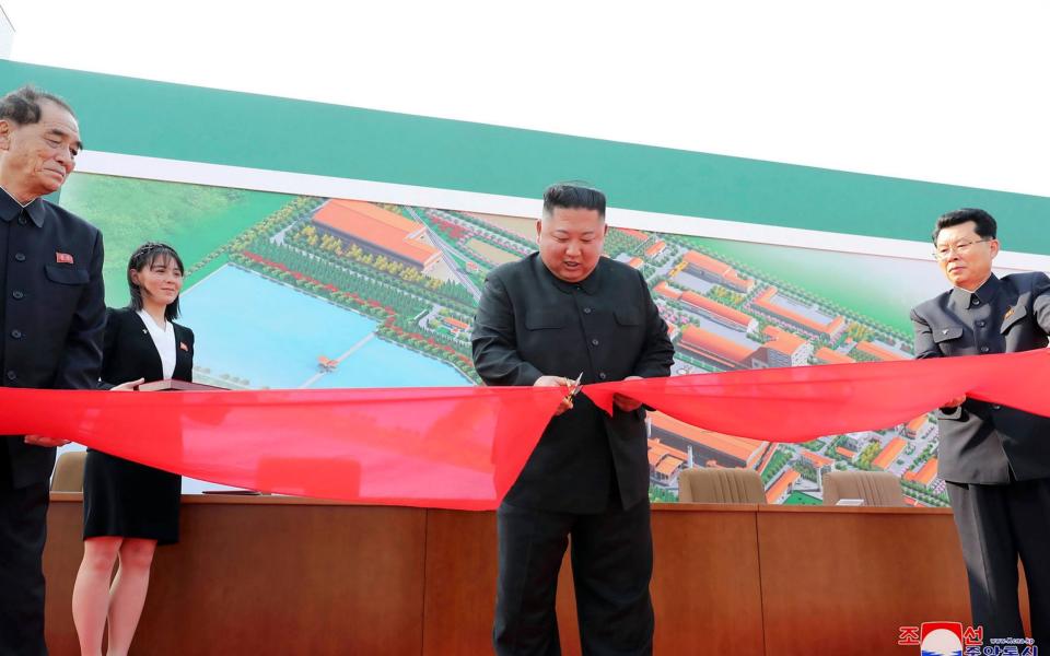 In this photograph provided by the North Korean government, North Korean leader Kim Jong Un, center, cuts a tape during his visit to a fertilizer factory in South Pyongan, near Pyongyang, on May 1, 2020 - KCNA via KNS 