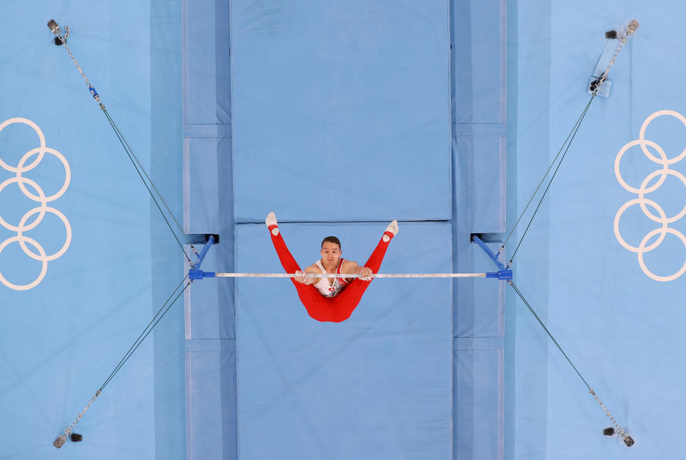 <p>Swiss gymnast Christian Baumann looks up from the horizontal bar during the July 26 men's team final. </p>