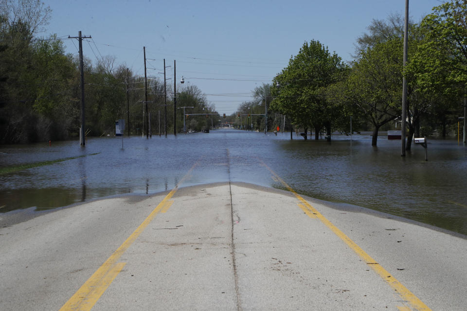 A view looking west on North Saginaw Road as the Tittabawassee River overflows, Wednesday, May 20, 2020, in Midland, Mich. People living along two mid-Michigan lakes and parts of a river have been evacuated following several days of heavy rain that produced flooding and put pressure on dams in the area. (AP Photo/Carlos Osorio)