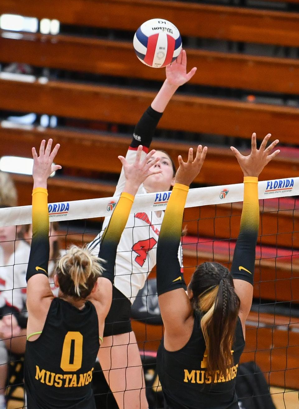 Camden Rahn of Middleburg drives the ball past the block of Maddie Johnson and Elena Martin of Merritt Island in the FHSAA state Class 5A volleyball tournament semifinal Wednesday, November 8, 2023. Craig Bailey/FLORIDA TODAY via USA TODAY NETWORK