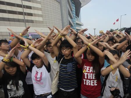Scholarism founder Joshua Wong (C) and other members gesture during a flag raising ceremony in Hong Kong October 1, 2014, celebrating the 65th anniversary of China National Day. REUTERS/Stringer