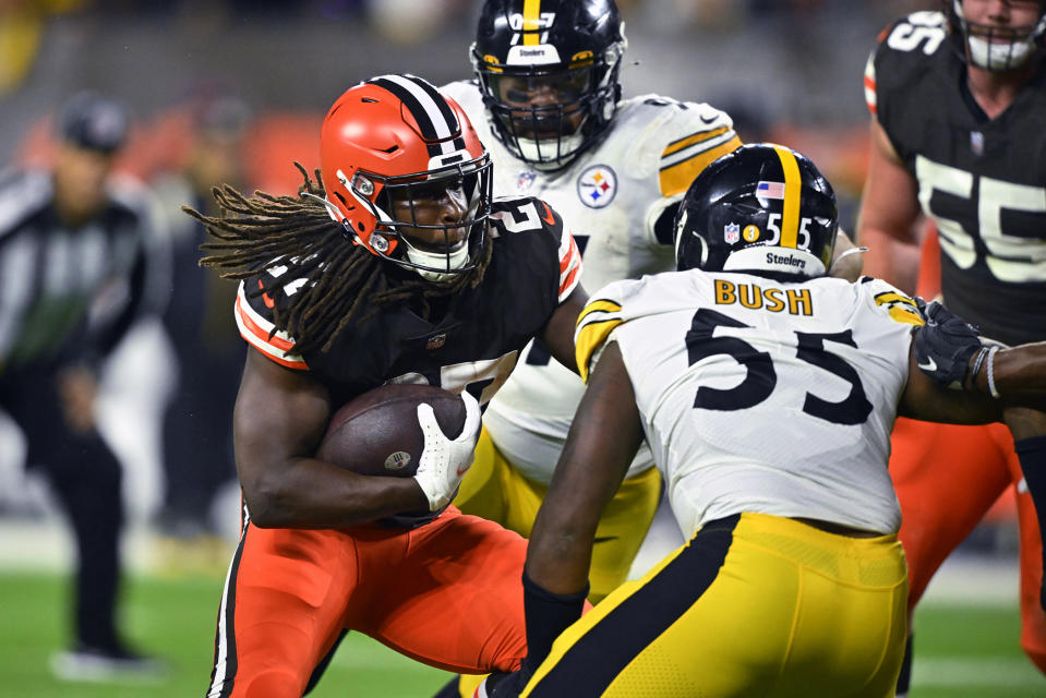 CORRECTS BROWNS PLAYER TO KAREEM HUNT, INSTEAD OF NICK CHUBB - Cleveland Browns running back Kareem Hunt (27) runs between Pittsburgh Steelers' Cameron Heyward (97) and Devin Bush (55) during the first half of an NFL football game in Cleveland, Thursday, Sept. 22, 2022. (AP Photo/David Richard)