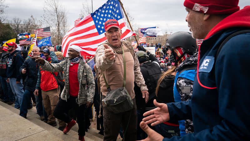 Ray Epps, in the red Trump hat, center, gestures to others as people gather on the West Front of the U.S. Capitol on Wednesday, Jan. 6, 2021 in Washington, DC.