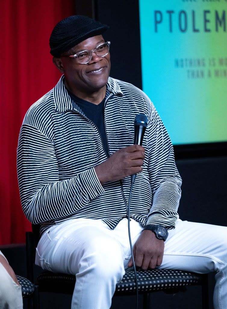 Samuel L Jackson smiling and holding a mic