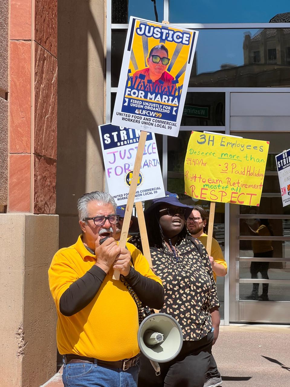 United Food and Commercial Workers Local 99 Organizing Director Martin Hernandez protests the firing of Maria Sanchez, a City Hall custodial worker who was fired for dress code by 3H & 3H. Behind are Angela Charles and David Sekaz, UFCW Local 99 organizers.