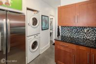 A view from inside the kitchen. The back corner, past the stacked washer-dryer, holds a half-bathroom. Next photo: The half-bath.