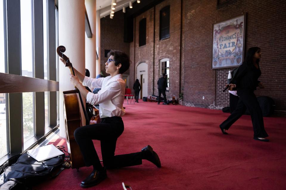 Luca Rodiguez, 13 of Shrewsbury, tunes a cello prior to a dress rehearsal at Mechanics Hall.