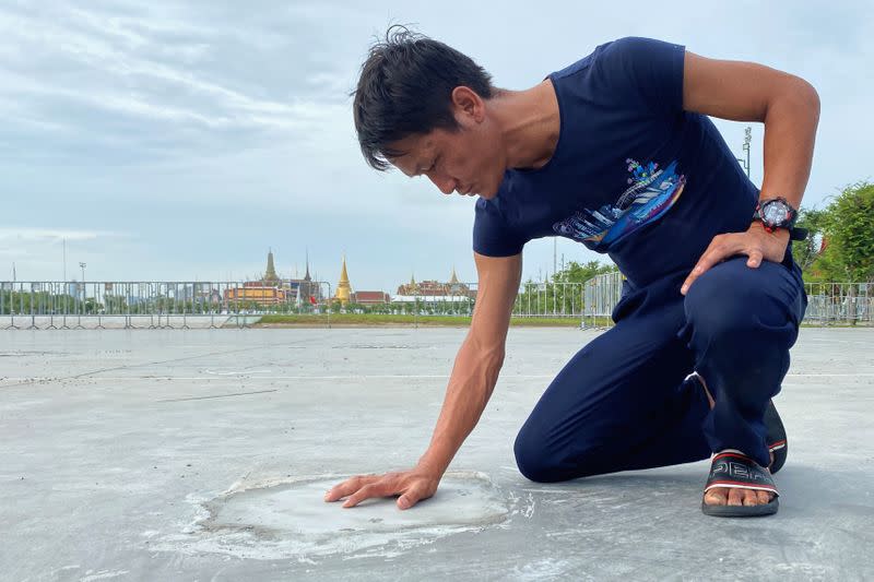 A man touches the place after a plaque placed by Thai pro-democracy protesters near the Grand Palace in Bangkok that declared that Thailand belongs to the people and not the king, was removed, according to police, in Bangkok