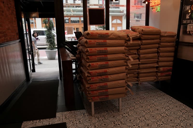 FILE PHOTO: A restaurant stacks bags of flour to keep the seating area closed as they offer take out only following the spread of Coronavirus disease (COVID-19), in the Manhattan borough of New York City