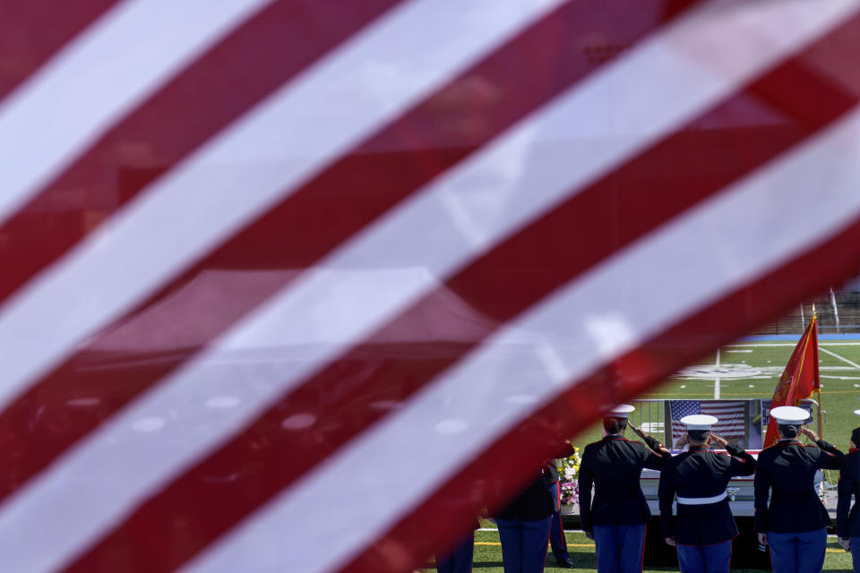 U.S. Marines salute the casket of fellow Marine, Sgt. Johanny Rosario Pichardo, who was among 13 service members killed in a suicide bombing in Afghanistan, during a public wake at Veterans Memorial Stadium in her hometown of Lawrence, Mass., Tuesday, Sept. 14, 2021. (AP Photo/David Goldman)